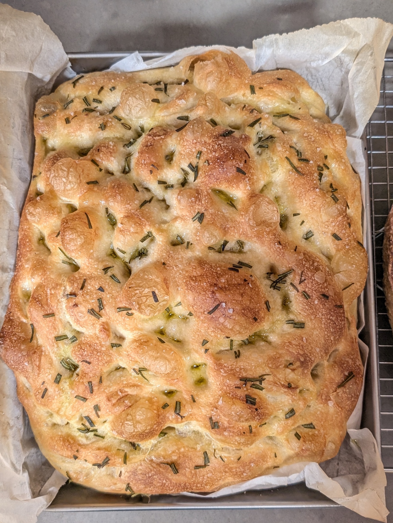 Rosemary and sea salt focaccia baked in a parchment-lined pan
